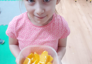 Dziewczynka częstuje zdrowymi owocami